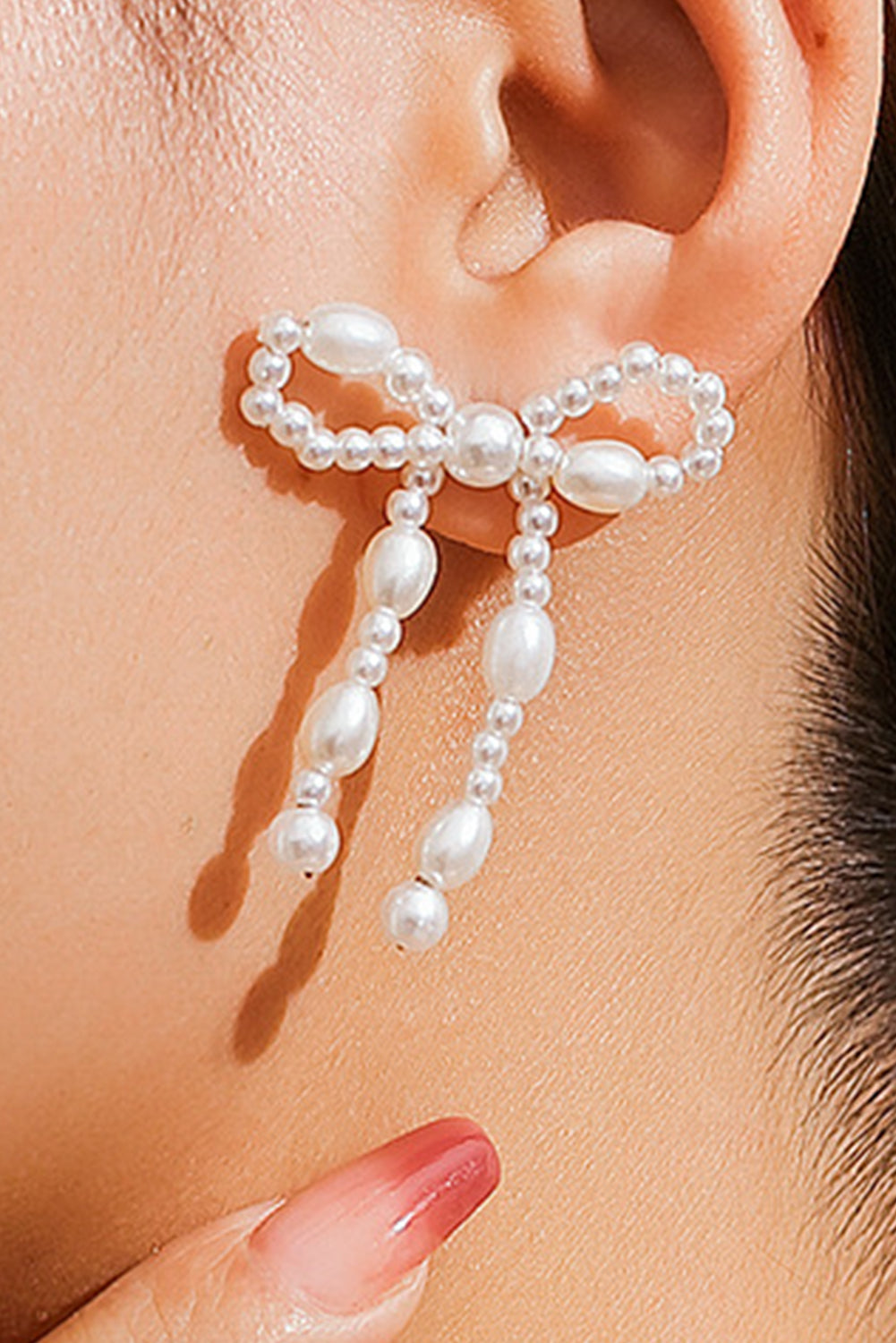 Boucles d'oreilles cloutées en perles et nœud papillon