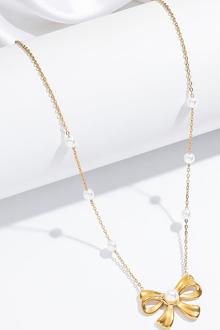 Collier avec pendentif en forme de nœud papillon plaqué orné de perles