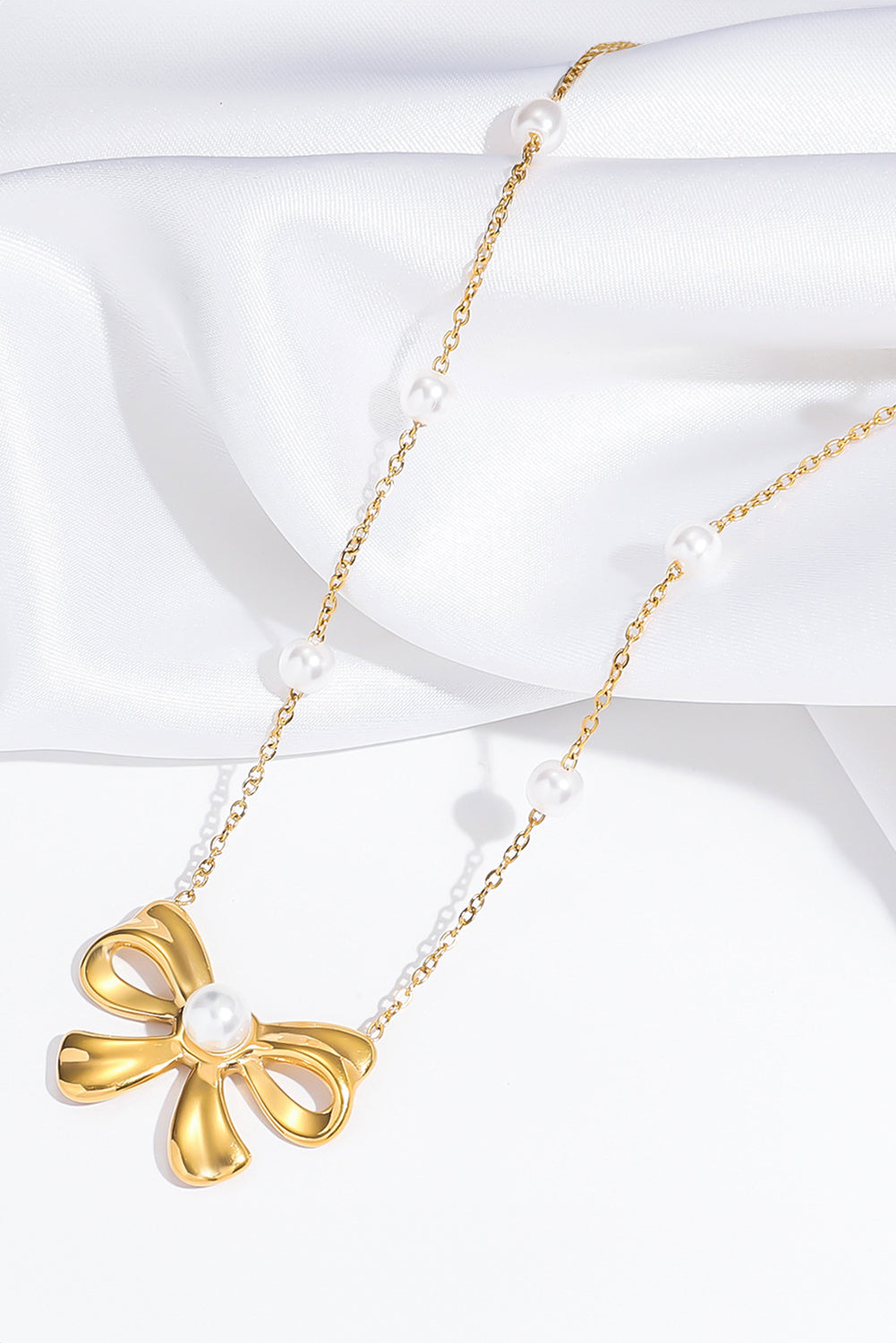 Collier avec pendentif en forme de nœud papillon plaqué orné de perles