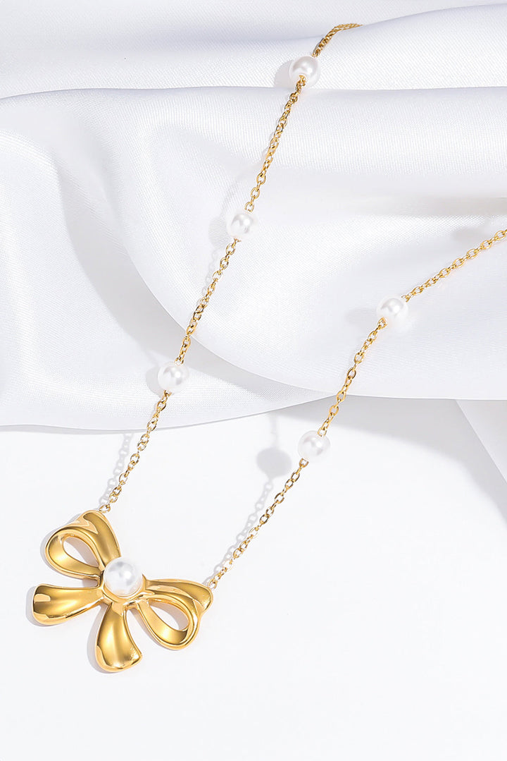 Collier avec pendentif en forme de nœud papillon plaqué orné de perles