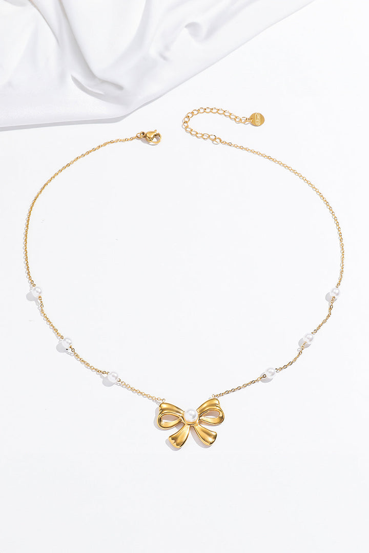 Collier avec pendentif en forme de nœud papillon plaqué orné de perles