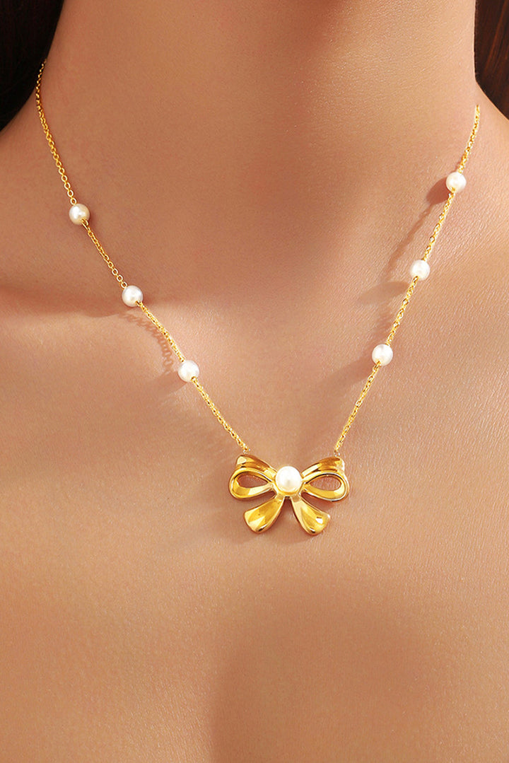 Collier avec pendentif en forme de nœud papillon plaqué orné de perles