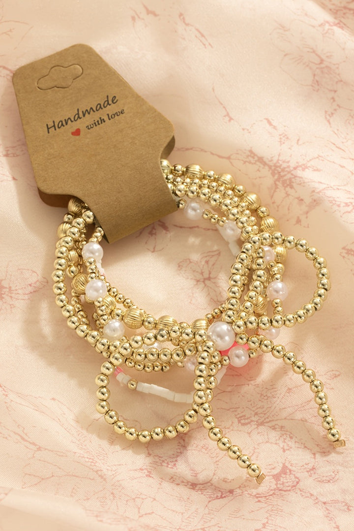 Bracelet multicouche plaqué orné de perles et de nœuds papillon
